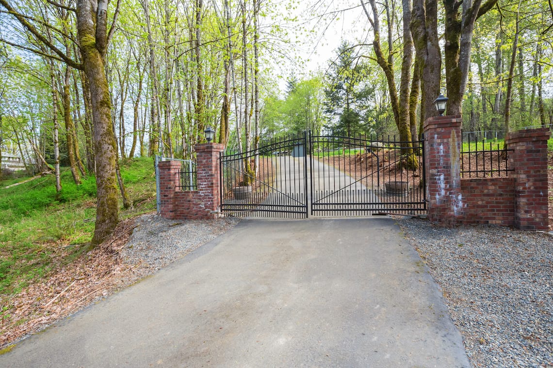 Ferforje Kapı - Credit: Image by Irina88w on DreamsTime - https://www.dreamstime.com/wrought-iron-driveway-gates-red-brick-columns-wrought-iron-driveway-gates-red-brick-columns-leading-to-beautiful-image111346994